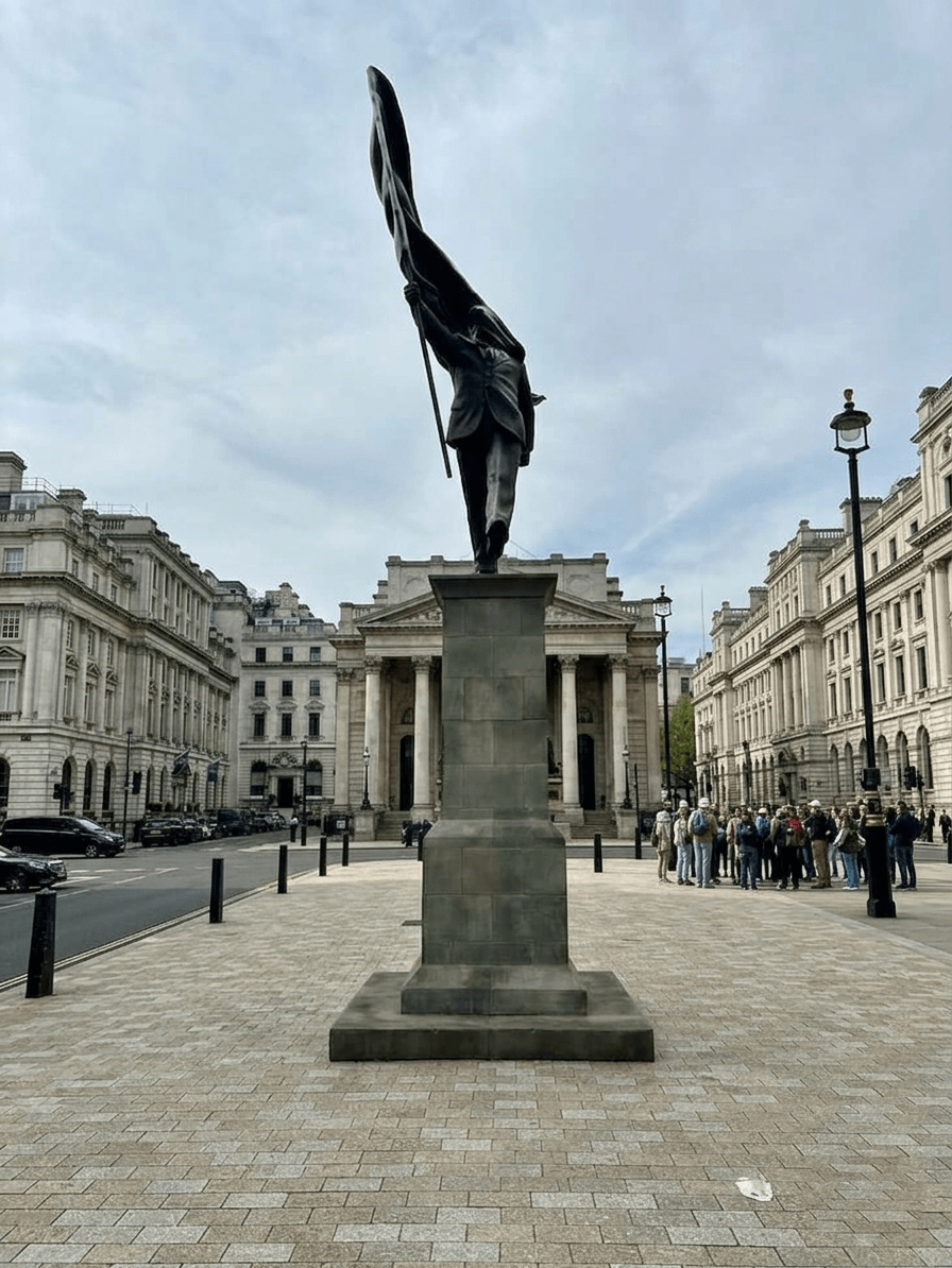 Statue showing a man in a suit holding a large flag on a pole